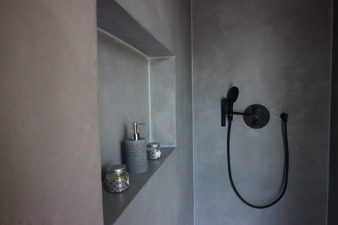 Fugenlose Dusche aus grauem Mikrozement mit integrierter Wandnische